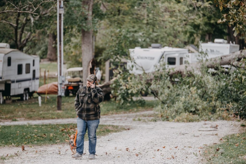 A tree worker beside fallen branches after storm damage
